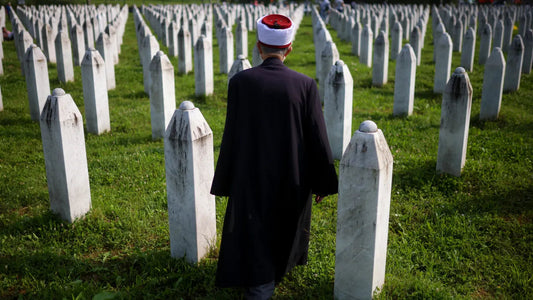 A Muslim man walks through a cemetery in Srebrenica, Bosnia and Herzegovina